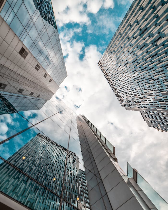 Low angle view of modern skyscrapers reflecting the cloudy sky in Brussels, Belgium.