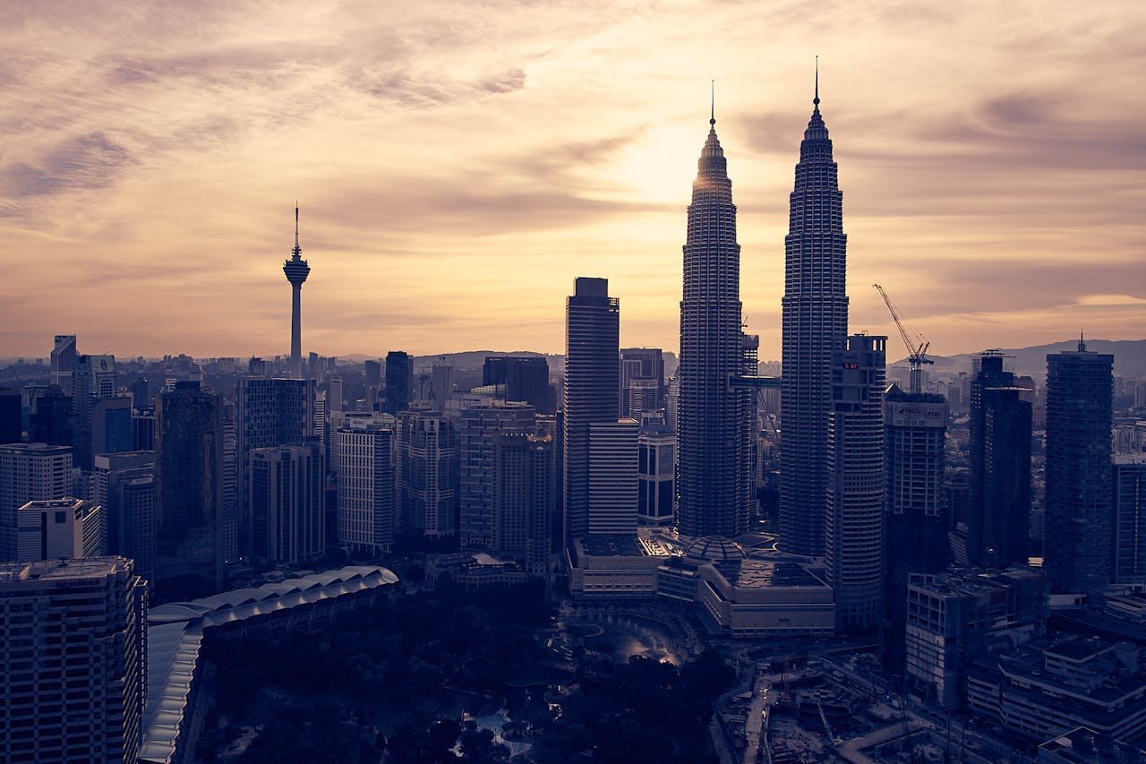 Explore Kuala Lumpur's skyline featuring the iconic Petronas Towers at sunset. Perfect for travel and architecture enthusiasts.